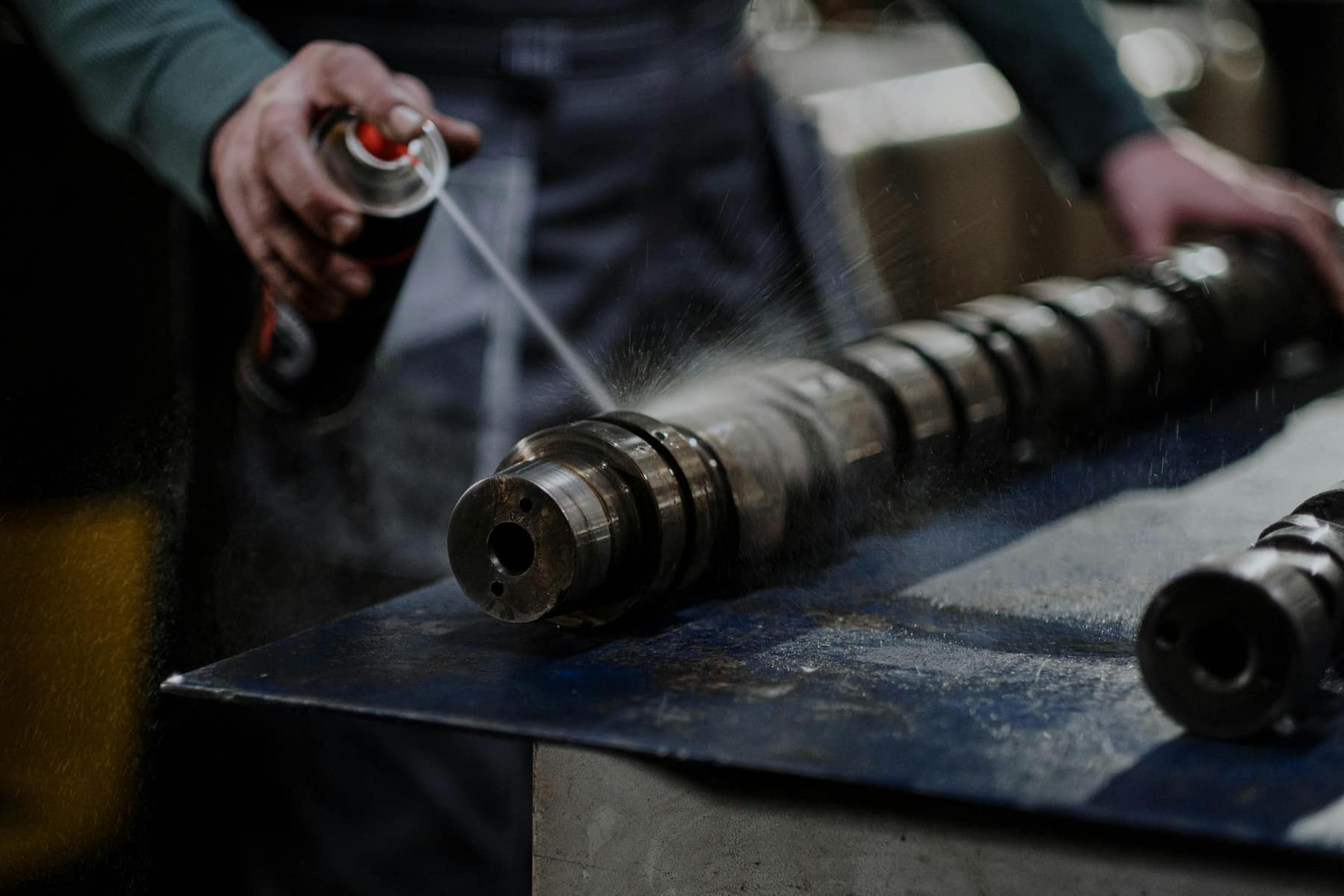 Monteur smeert een machineonderdeel